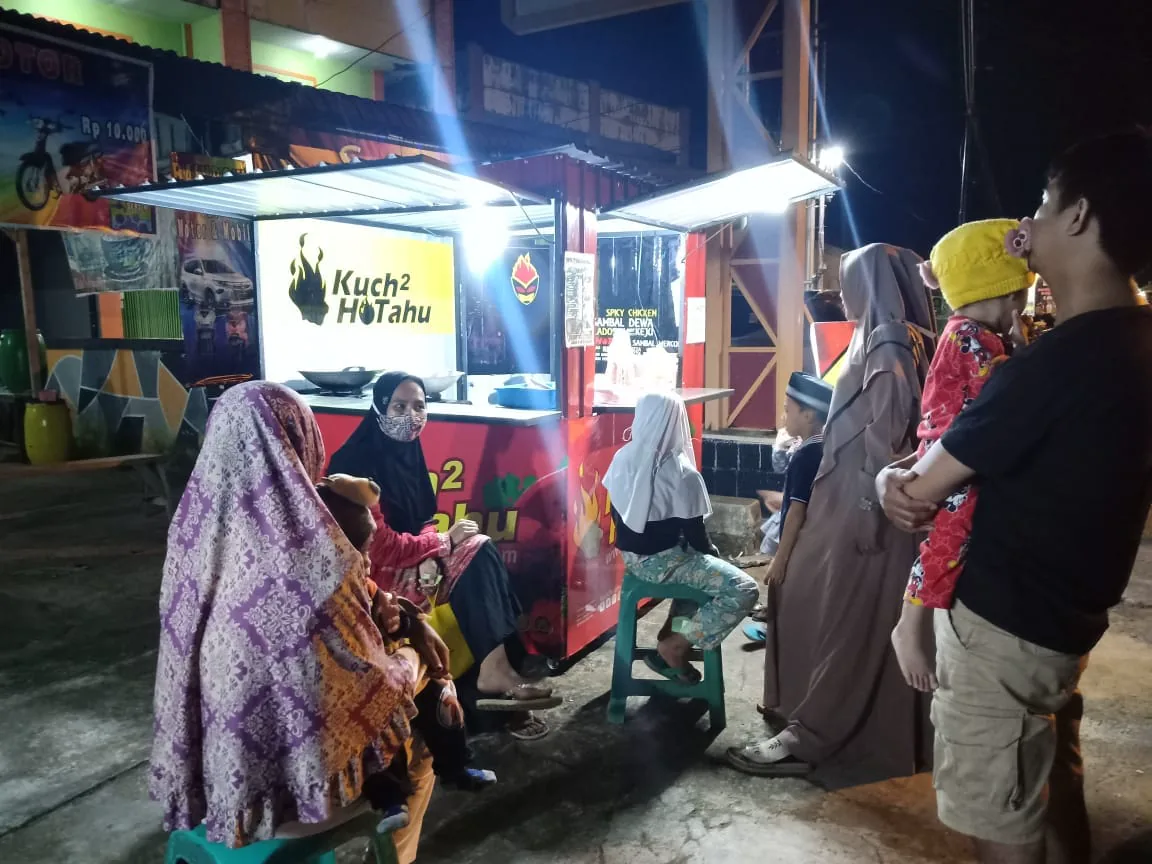 Pelanggan menunggu pesanan di outlet Kuch2hotahu pada malam hari